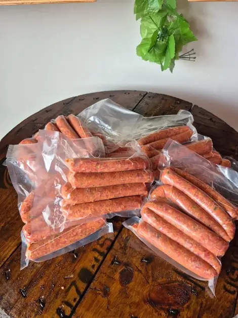Chorizos empacados al vacío, acomodados sobre una tabla de madera